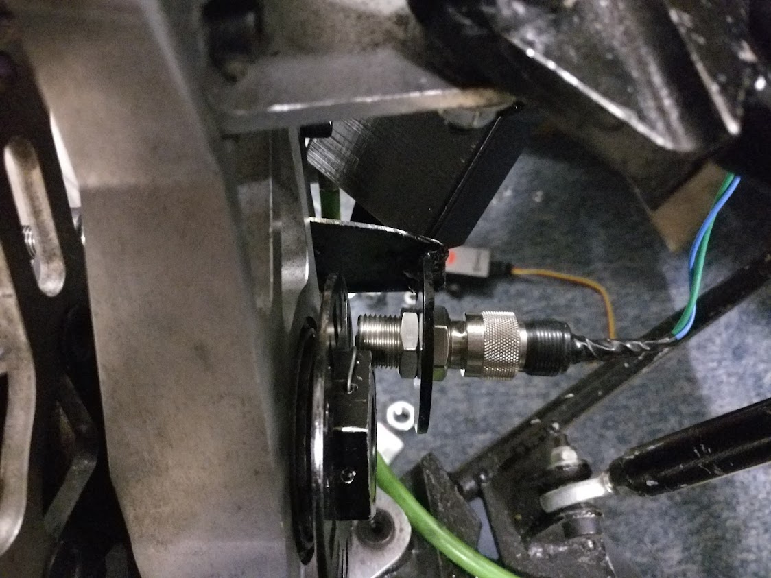 Reluctor sensor mounted to the upright, facing the toothed ring